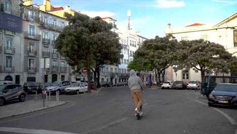 Junges-Paar-Fährt-Mit-Einem-Roller-Auf-Einer-Straße-In-Der-Stadt-Lagos-In-Portugal