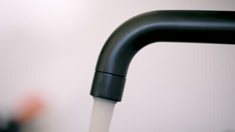 Static-side-close-up-of-black-water-faucet-being-turned-on-and-off