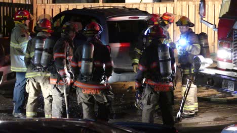 Firefighters-preparing-for-emergency-near-fire-truck-at-night