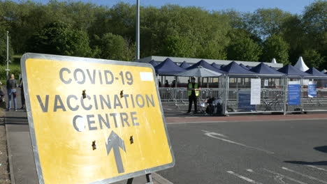 Entrance-to-a-COVID-19-vaccination-centre-with-people-queueing-for-their-coronavirus-vaccine