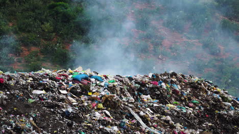 Stack-of-different-types-of-large-garbage-dump,-plastic-bags,-and-trash-burning-near-paddy-rice-terraces,-agricultural-fields-of-Mu-Cang-Chai,-mountain-in-Vietnam-in-environmental-pollution-concept