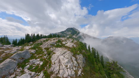 Drone-Flying-Over-Rocky-Mountain-With-Green-Pine-Trees-In-Squamish-Town,-British-Columbia,-Canada