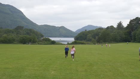 Turistas-Corriendo-Hacia-El-Lago-Muckross-En-El-Parque-Nacional-De-Killarney,-Condado-De-Kerry,-Irlanda