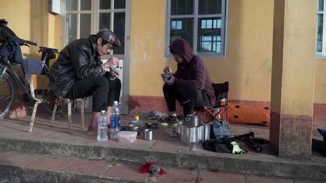 Dos-Hermanos-Vietnamitas-Comiendo-En-Silencio-En-Zona-Urbana