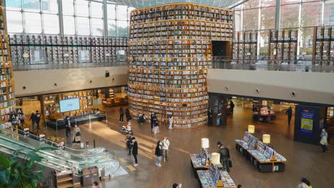 People-move-around-watching-and-choosing-books-in-Starfield-Library-in-Coex-Mall-in-Gangnam-District,-Seoul-city,-Korea---static-timelapse