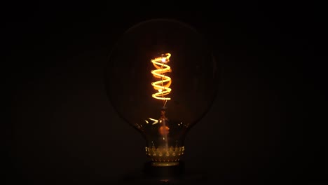 Light-bulb-flickering-over-dark-black-background