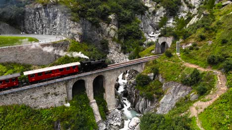 Aerial:-steam-train-crossing-a-river-and-entering-a-tunnel