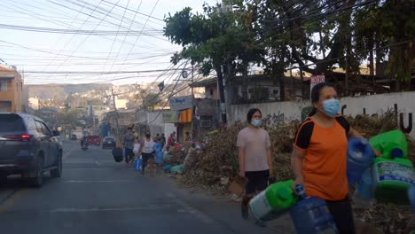 Locals-Walking-In-The-Street-With-Their-Plastic-Containers-To-Get-Water