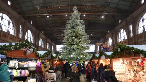 Menschenmassen-Besuchen-Die-Stände-Unter-Dem-Großen,-Mit-Kristallen-Geschmückten-Weihnachtsbaum