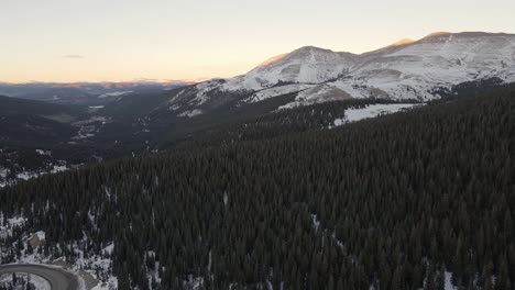 Aerial-footage-over-Highway-9-at-sunset,-panning-from-Hoosier-Ridge-and-Red-Mountain-towards-the-town-of-Breckenridge