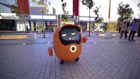Expo-2020,-Dubai,-5.-Februar-2022-–-Expo-Roboter-Orange-Opti-Unterstützt-Einen-Gast-Beim-Helfen-Und-Singen