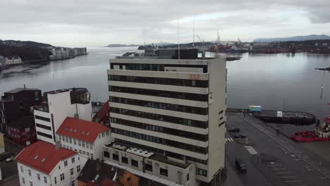 Norled-Como-Sede-En-Stavanger,-Noruega---Edificio-De-Oficinas-Con-Fondo-De-Fiordo-Visto---Antena-Inversa-Ascendente-Desde-El-Primer-Plano-Hasta-La-Descripción-General