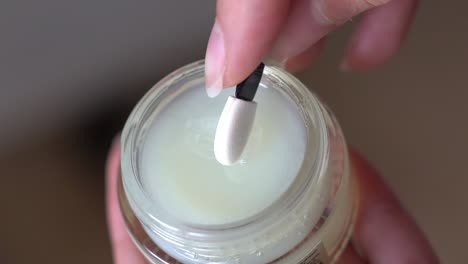 Pick-up-hygienic-lipstick-from-a-jar-with-a-stick