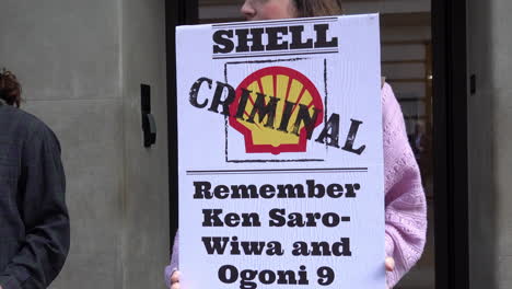 A-climate-change-protestor-holds-a-placard-calling-the-Shell-energy-company-“criminal”-outside-the-Mayfair-Hotel-during-the-Africa-Energies-Summit