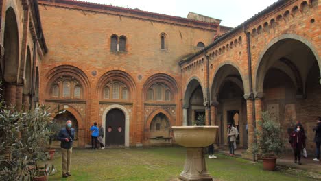 Tourists-In-The-Courtyard-Of-The-Basilica-di-Santo-Stefano,-Bologna,-Italy---wide-shot