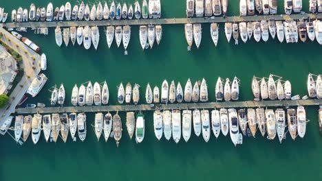 aerial-top-down-view-of-sailboats-docked-in-the-Bodrum-marina-with-turquoise-green-water-on-a-summer-afternoon-during-sunset