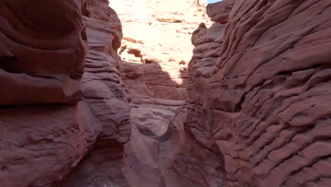 Passing-through-a-very-narrow-sandstone-canyon,-passage-between-the-rocks