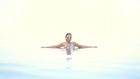 Beautiful-Woman-in-Tropical-Paradise-Enjoying-in-Infinity-Pool-Collided-With-Skyline
