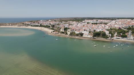 Aerial-view-of-Vila-Nova-de-Milfontes-on-bank-of-Rio-Mira-estuary,-Portugal