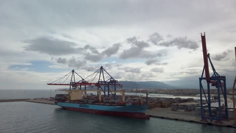 Static-wide-shot-of-container-ship-loaded-with-freight-containers-docked-in-Italy-port