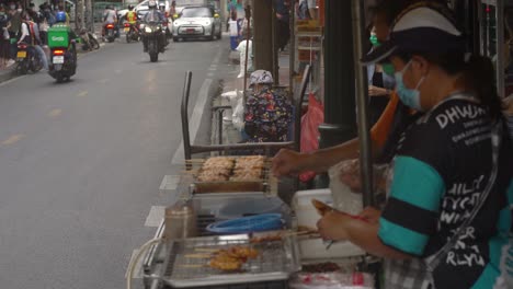 Street-food-stall-selling-skewers-at-Soi-Sala-Daeng-1,-Si-Lom