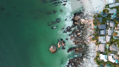 top-down-of-rocky-white-sand-coastline-at-Clifton-Beach-in-Cape-Town-at-sunset,-aerial