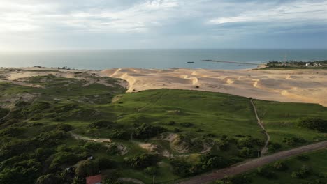 Wunderschöne-Aufnahme-Mit-Der-Drohne,-Die-Sich-Mitten-In-Den-Dünen-Und-Der-Vegetation-In-Richtung-Meer-Im-Nordosten-Brasiliens-Bewegt,-Magisches-Licht-Des-Sonnenuntergangs