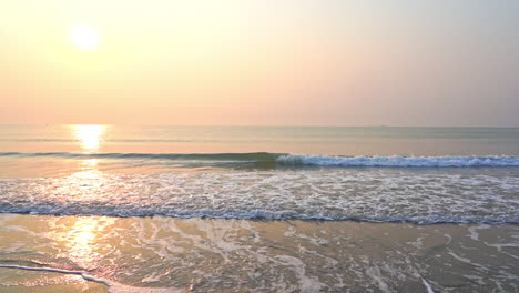 Caribbean-Sea-Waves-Breaking-on-Sandy-Beach-With-Evening-Sun-on-Horizon,-Slow-Motion
