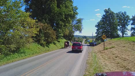 An-Amish-Horse-and-Buggy-Trotting-Down-a-Country-Road-Passing-Cars,-in-Slow-Motion,-on-a-Beautiful-Sunny-Day