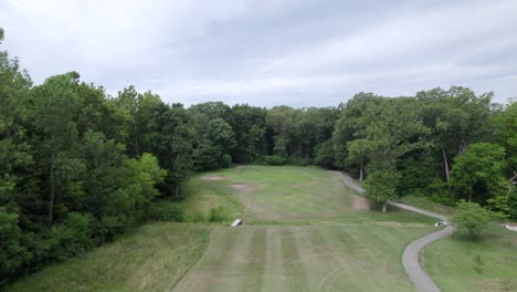 fly-over-golf-course-hole,-aerial-drone-rise
