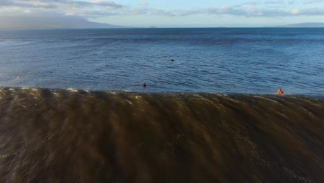 drone-follows-big-wave-as-surfers-duck-dive-something-big-swims-in-the-murky-water