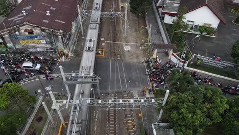 Luftaufnahme,-Der-Zug-Fährt-über-Eine-Belebte-Kreuzung,-Der-Zug-Hält-Am-Bahnhof-Lempuyangan-Yogyakarta