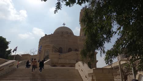 Vista-De-La-Iglesia-De-San-Jorge-En-El-Cairo-Copto-De-Egipto-Y-Visitantes-Subiendo-Escaleras-Hacia-Ella