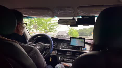 Rückansicht-In-Zeitlupe-Eines-Südkoreanischen-Taxifahrers-Mit-Gesichtsmaske-In-Einem-Elektroauto,-Der-Tagsüber-In-Der-Stadt-Seoul-Fährt---Männlicher-Taxifahrer,-Der-Während-Der-Fahrt-Handschuhe-Trägt---Südkorea,-Seoul,-4k---Nahaufnahme