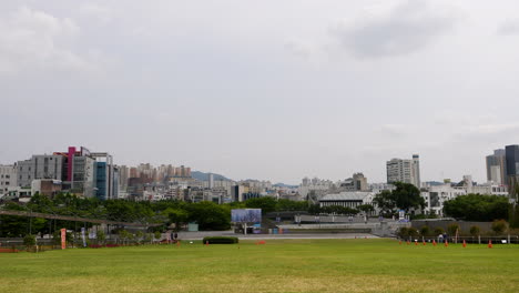 Statische-Weitwinkelaufnahme-Des-Rasenparks-Und-Der-Skyline-Der-Stadt-Gwangju-Im-Hintergrund-An-Bewölkten-Tagen---Südkorea,-Asien
