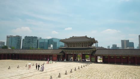 Geunjeongmun-Tor-Auf-Städtischem-Seoul-Hintergrund-Mit-Touristen,-Die-In-Der-Koreanischen-Wahrzeichen-Geunjeongjeon-Halle-Sehenswürdigkeiten-Besichtigen