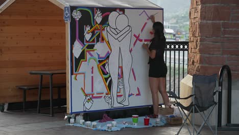 Girl-painting-a-mural-in-public,-Glenwood-Springs,-Colorado