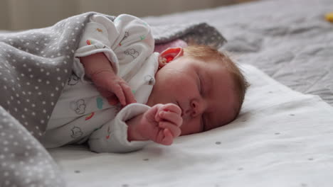 Handheld-mid-shot-of-newborn-baby-girl-sleeping-peacefully-on-her-side