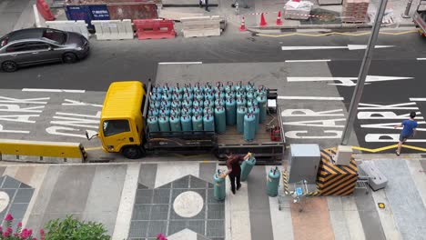 Hombre-Cargando-Camión-Con-Cilindros-De-Gas,-Transporte-Seguro,-Centro-De-Singapur
