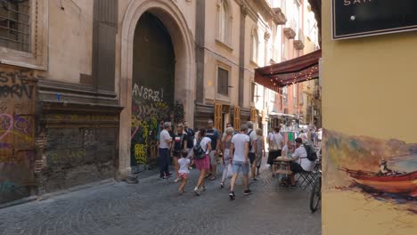 Tourists-walking-along-artsy-streets-of-Napoli,-cafes-and-restaurants,-Italy