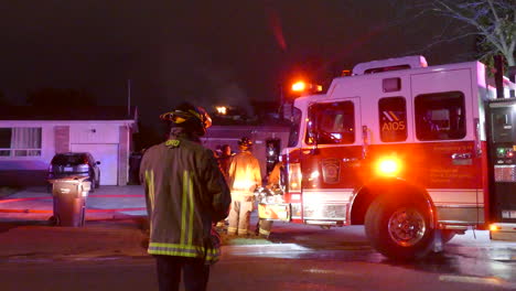 Eine-Gruppe-Von-Feuerwehrleuten-Versammelt-Sich-Nachts-Vor-Einem-Brennenden-Haus-In-Kanada