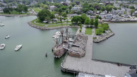 Aerial-view-orbiting-the-wooden-Mayflower-schooner-docked-in-cloudy-Plymouth,-USA---circling,-drone-shot