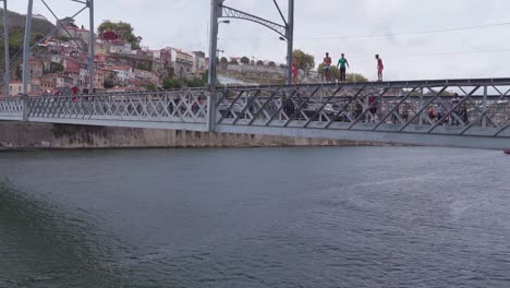 Local-guy-jumps-off-the-Dom-Luis-I-bridge-for-entertainment-in-Porto,-Portugal