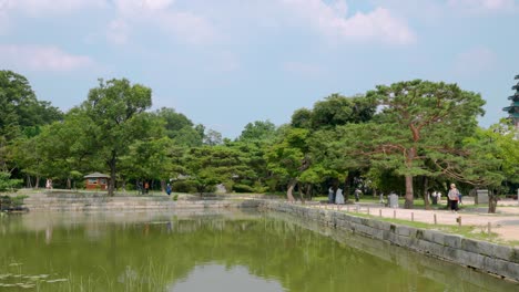 People-explore-Korean-traditional-architecture-walking-by-Hyangwonji-Pond-in-Gyeongbokgung-Palace-in-Seoul