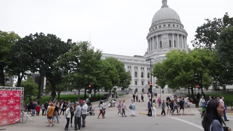 A-group-of-people-walking-around-the-grounds-at-the-state-capitol-building-in-Madison,-Wisconsin