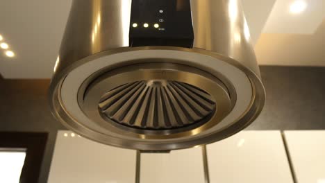 Stainless-Steel-Round-Extractor-Fan-Hanging-From-Kitchen-Ceiling