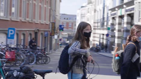 Teenage-girl-students-in-medical-masks-walking-down-the-street---close-up