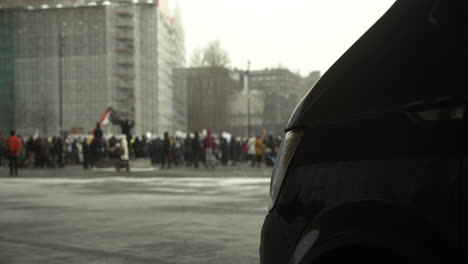 Weitwinkelaufnahme-Der-Menge-Der-Demonstranten,-Die-Sich-Zu-Den-Covid-19-Protesten-In-Helsinki-Versammelt-Haben,-Schwarzes-Auto-Im-Bild