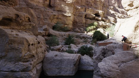 Excursionistas-Alrededor-De-Las-Piscinas-Del-Cañón-Wadi-Shab,-Omán,-Plano-Amplio-De-Mano