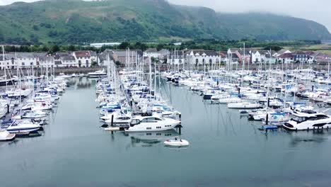 Luxury-yachts-and-sailboats-parked-on-misty-mountain-range-retirement-village-marina-slow-orbit-right